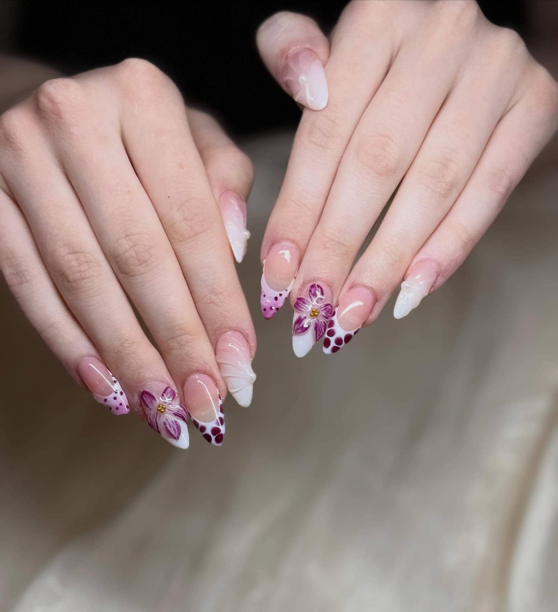 Pink French tips with delicate flowers on long almond nails