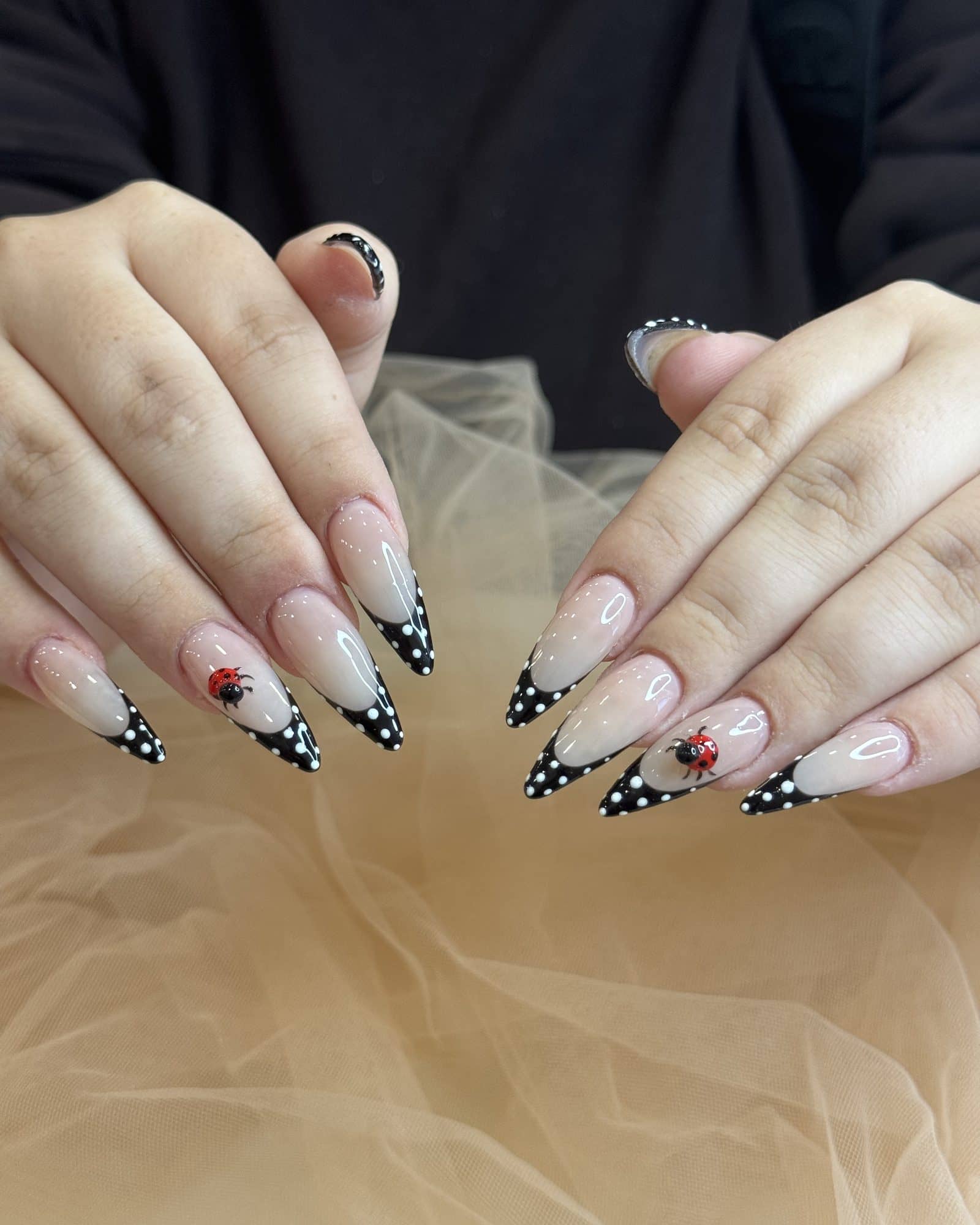 Black polka-dot French tips on long stiletto nails