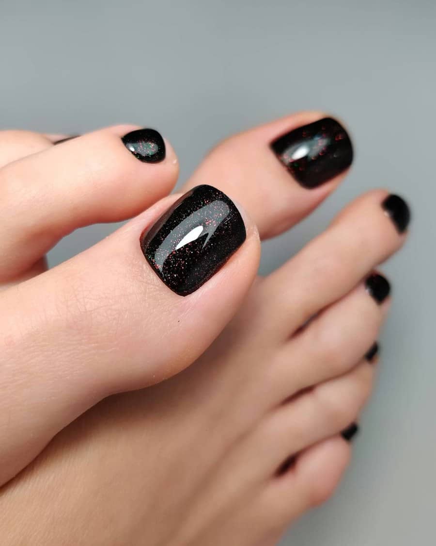 Close-up of a glossy black glitter shellac pedicure
